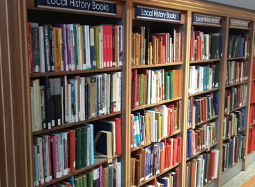 Books on shelves in the local history library at Kingston History Centre