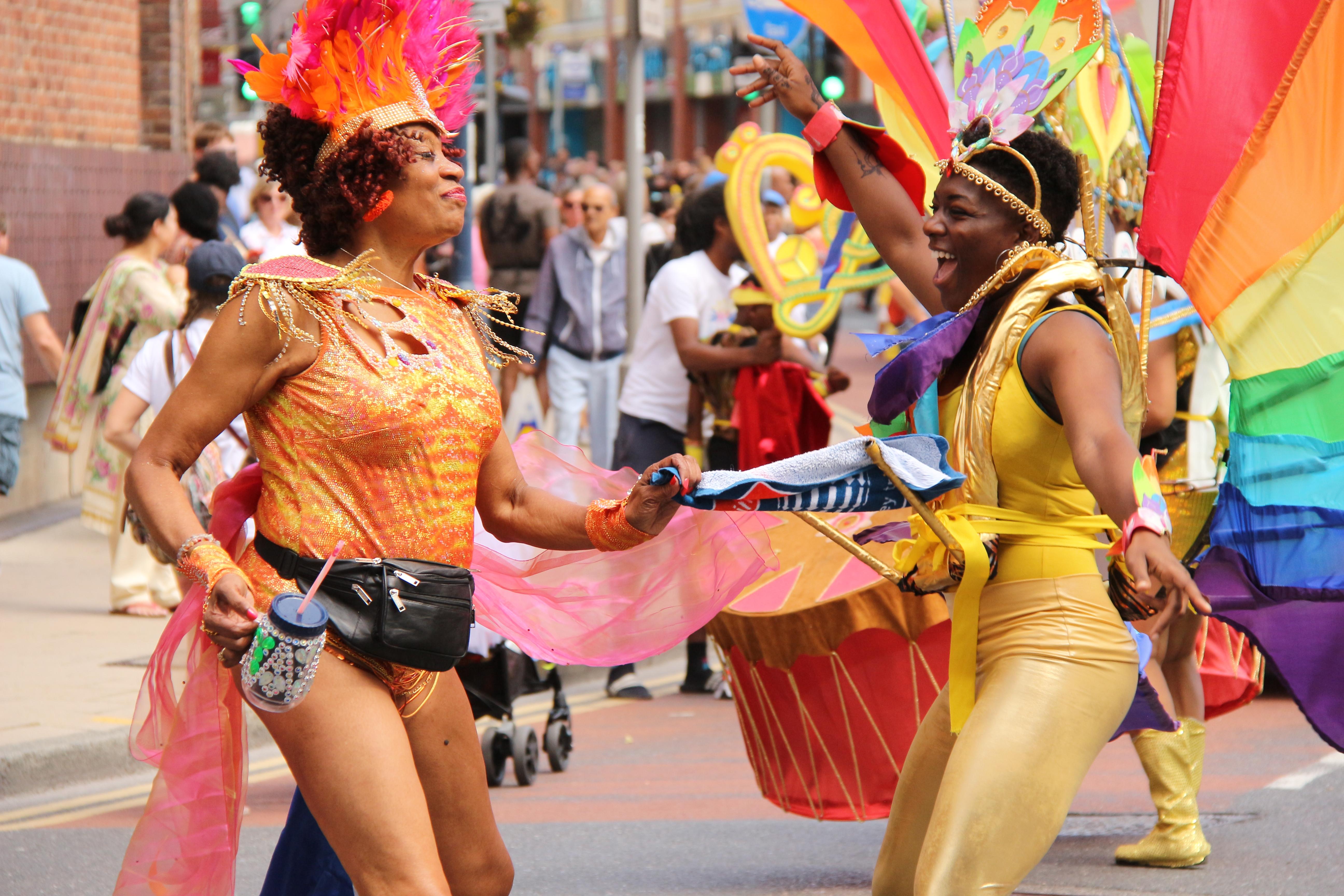 2 women wearing colourful costumes, dancing at Kingston Carnival 2019.