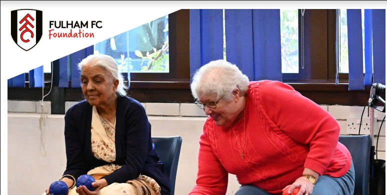 Two ladies sitting with the fulham football club logo