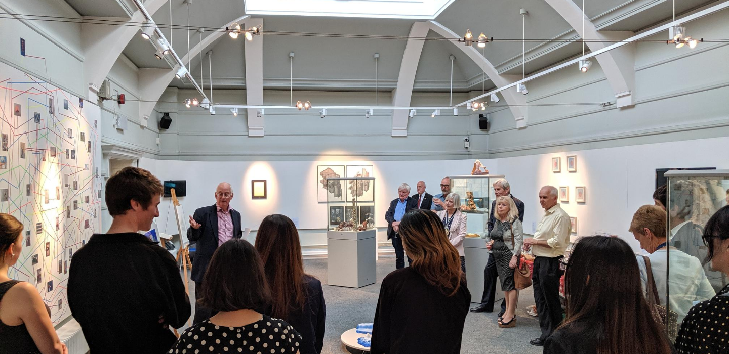 A group of people looking at an exhibition in Kingston Museum's gallery