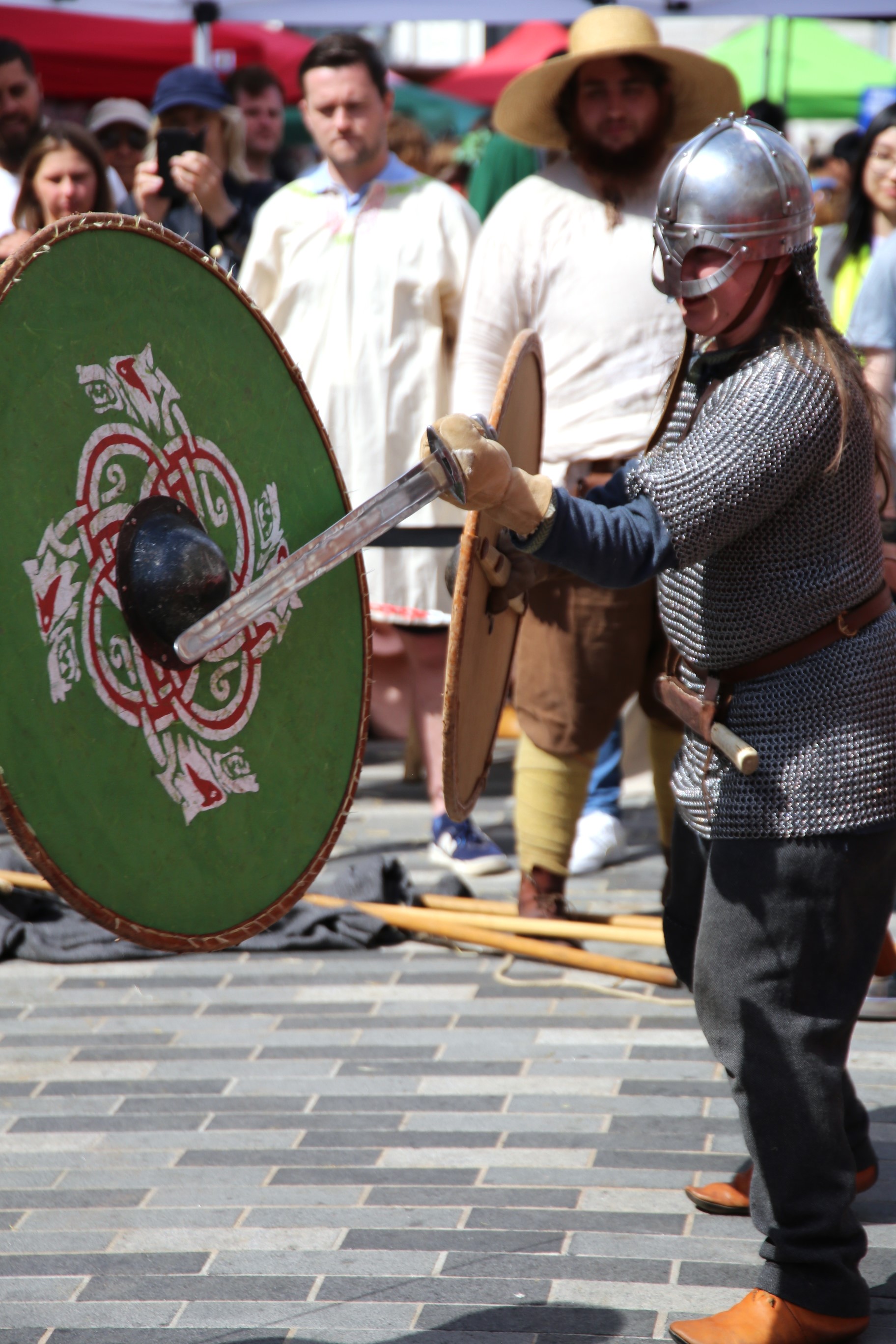 Image of a person dressed as a saxon fighting, they have a shield and sword and are wearing armour
