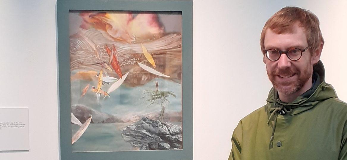 Dr Paul Micklethwaite stood next to artwork 'Man on a Tree'.