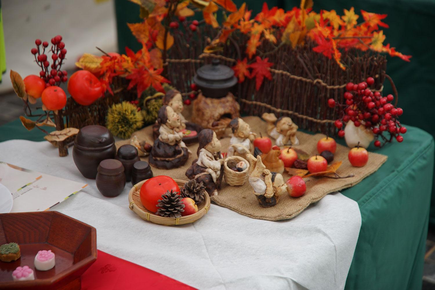 Vegetables on a table next to Korean figurines