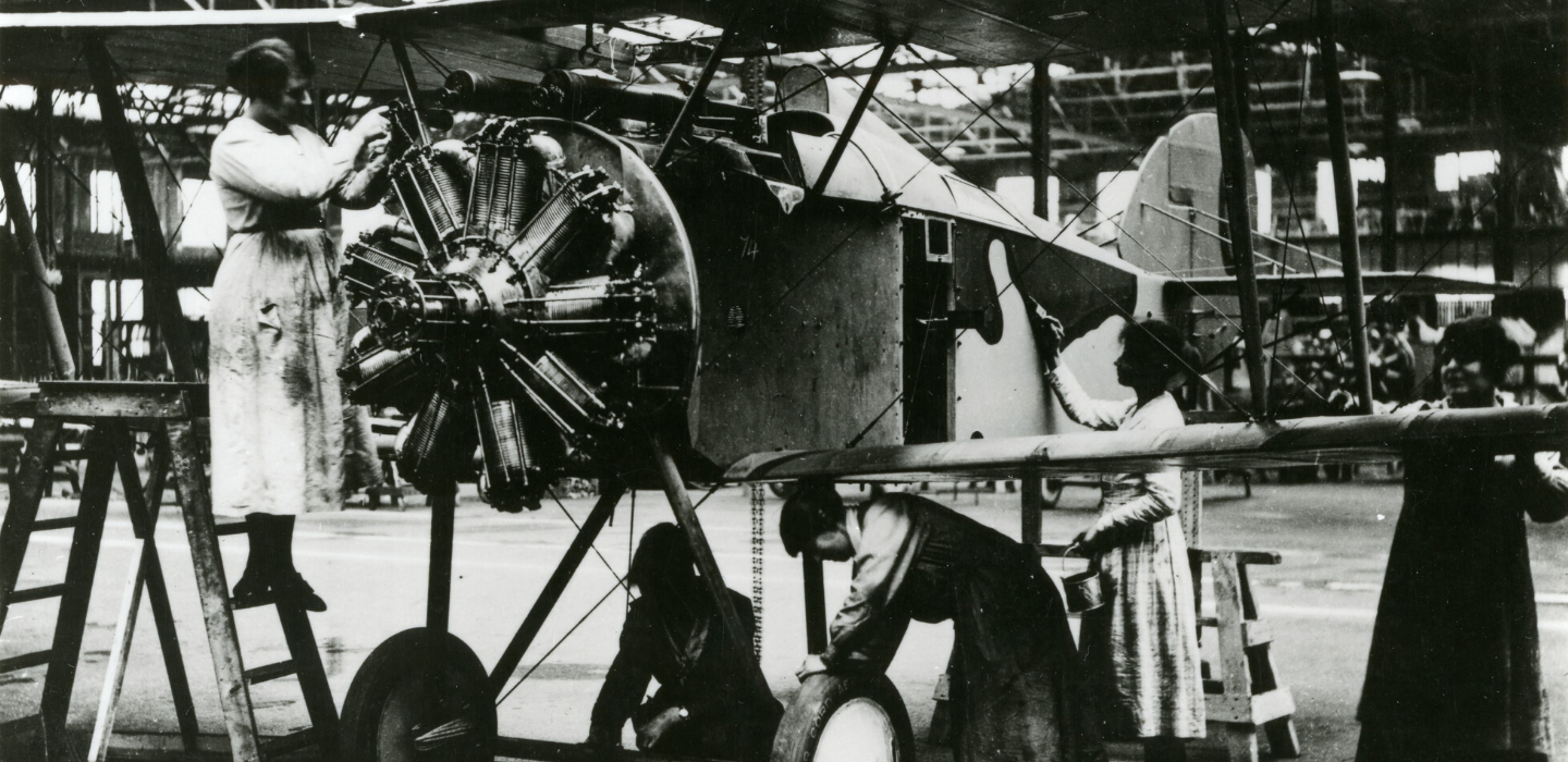 A photograph of women working on a plane in an aircraft factory.