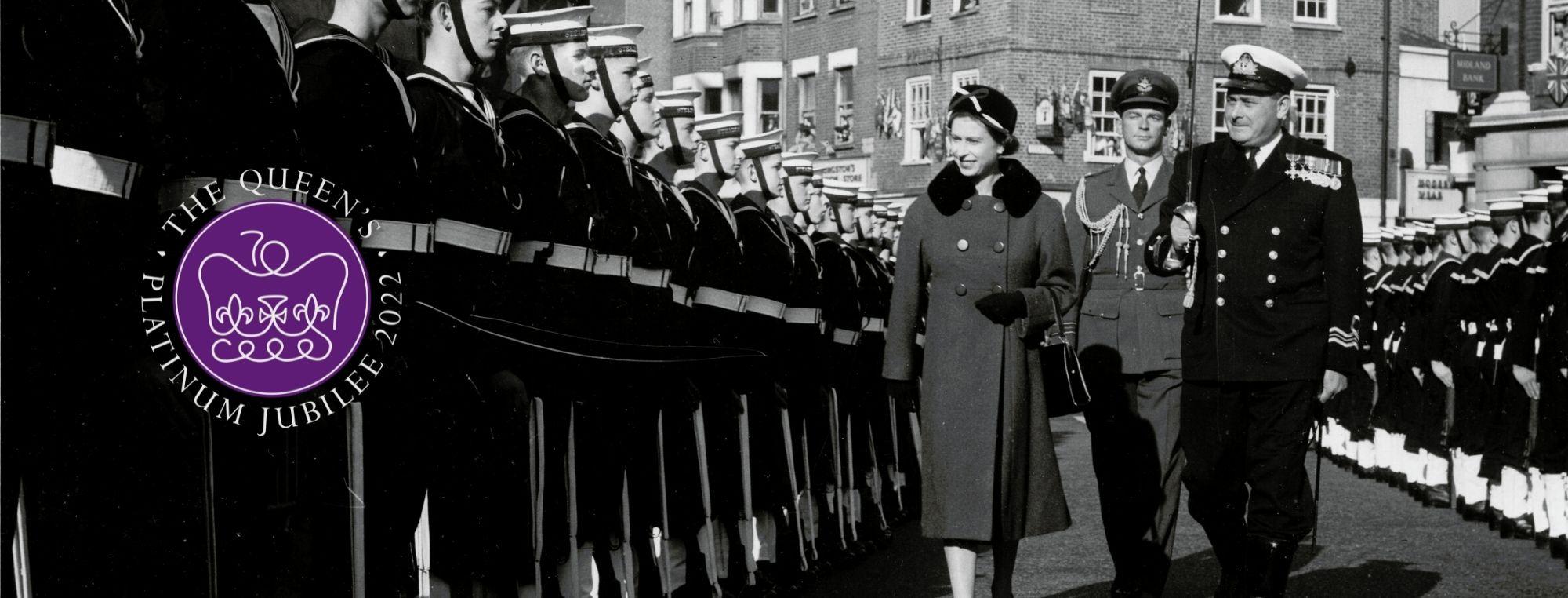 The Queen walking through Kingston Market place beside a row of Cadets