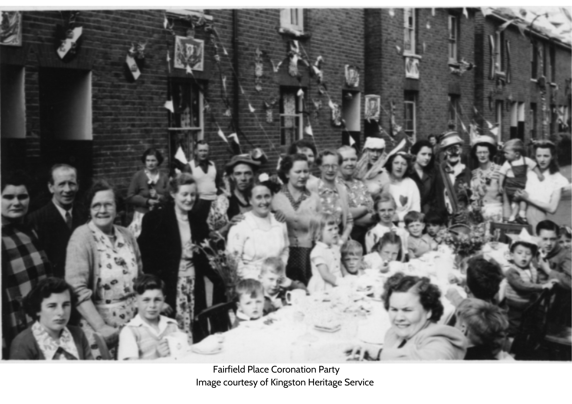 Old black and white image of fairfield place coronation party. Side image of people celebrating on one side of a long table. 