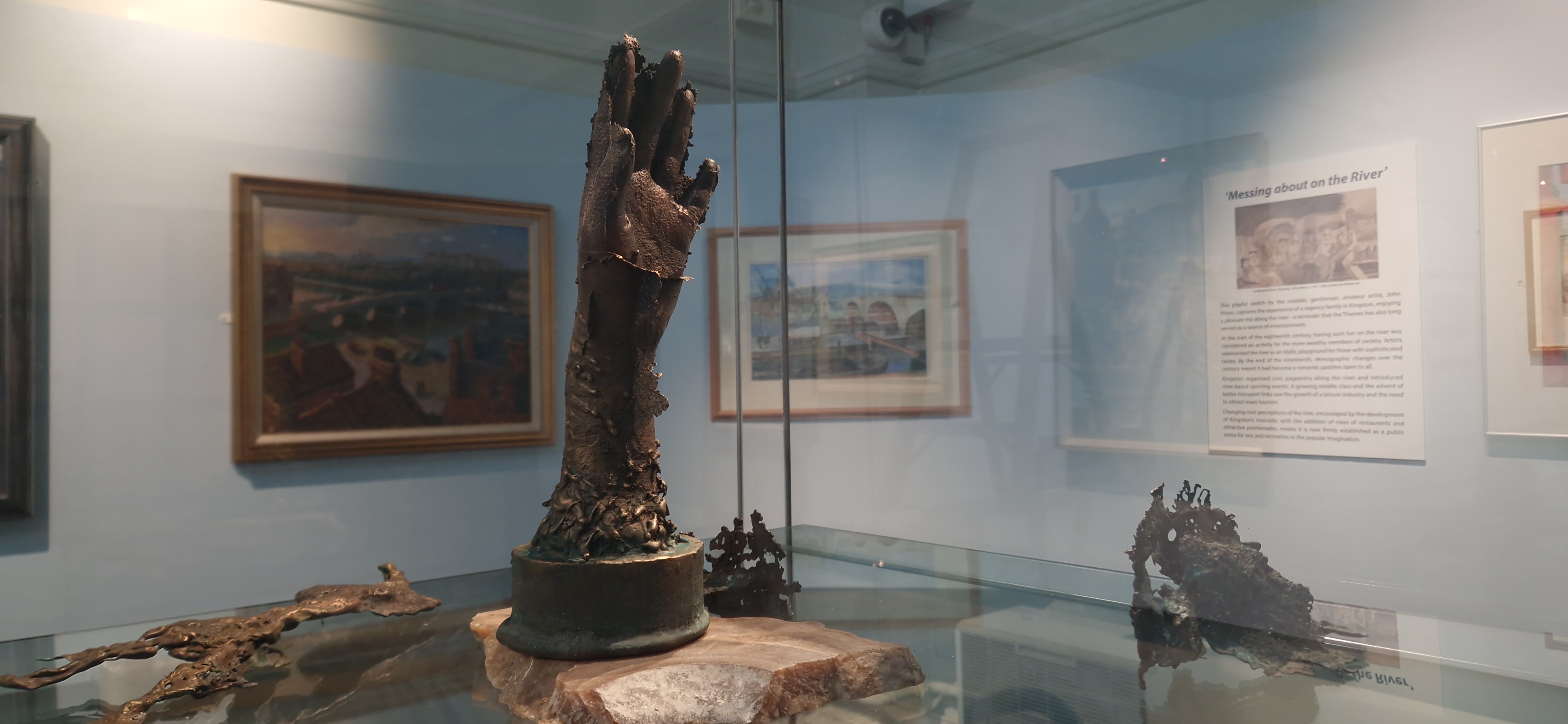 A sculpture of a nymph's hand reaching up through the surface of the water