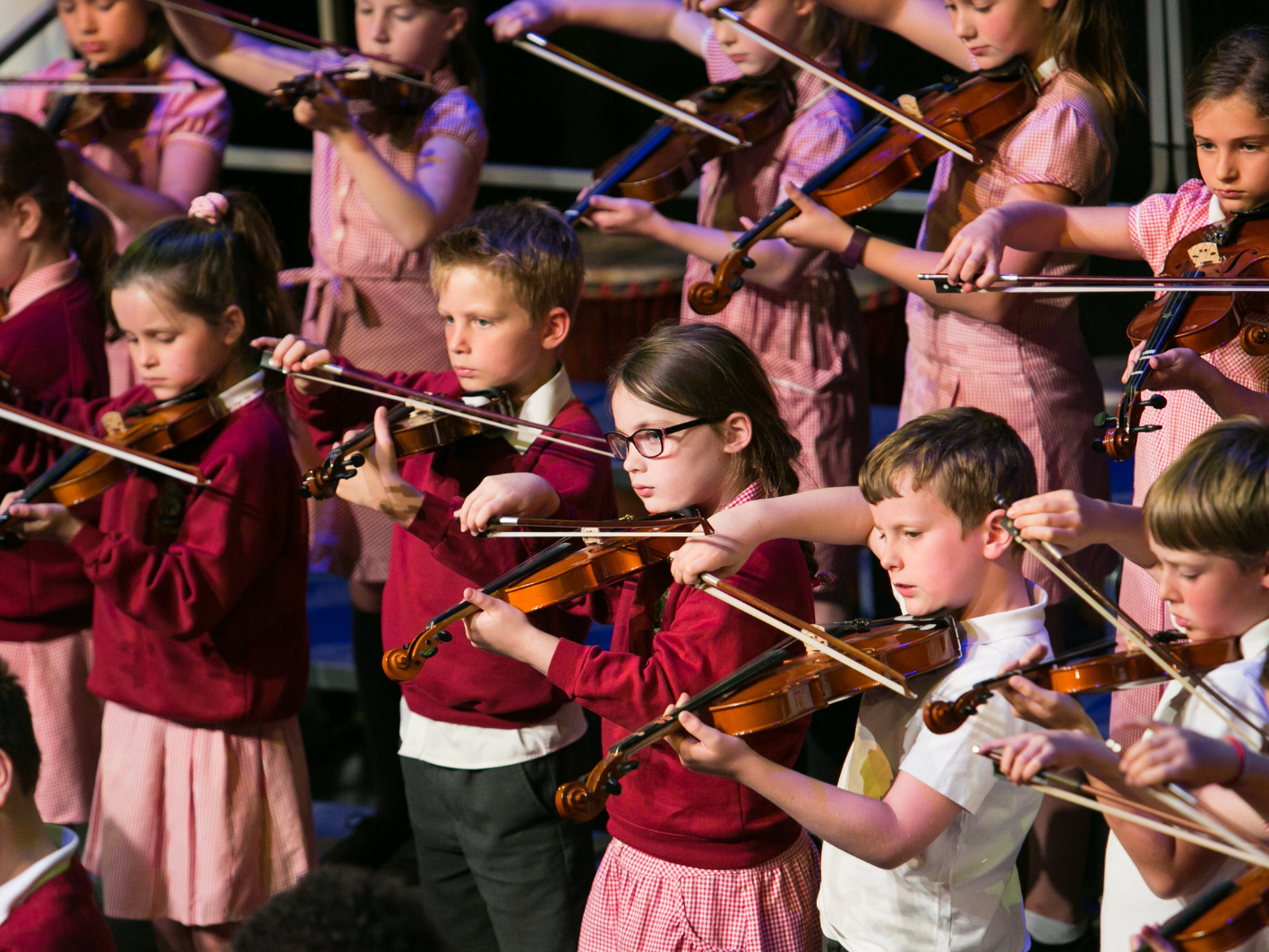 a picture of children playing violin together