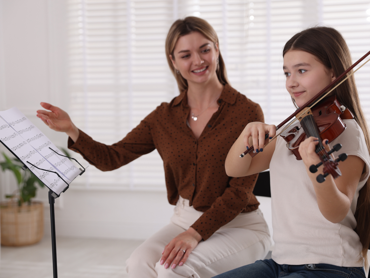 a picture of a girl having a violin lesson